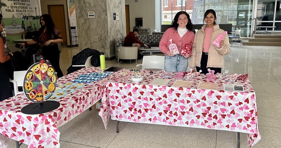 two students behind Valentine themed table